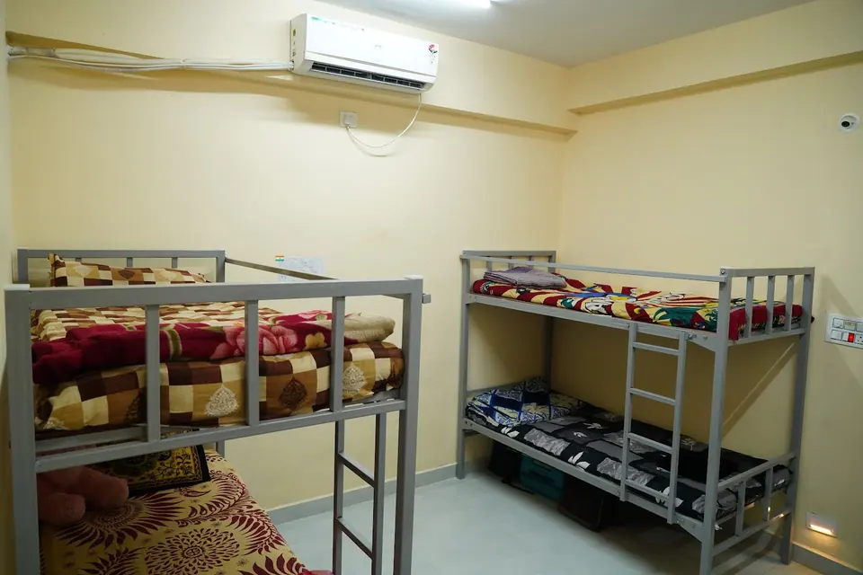 An air-conditioned hostel room with bunk beds